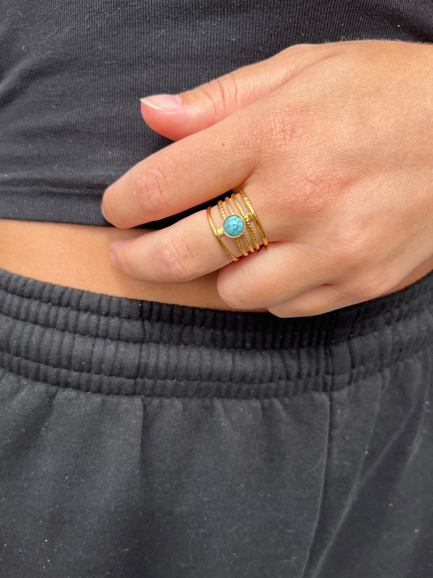 Celia is a 18k AAA gold plated ring with 5 bands of gold and a aqua blue centre stone