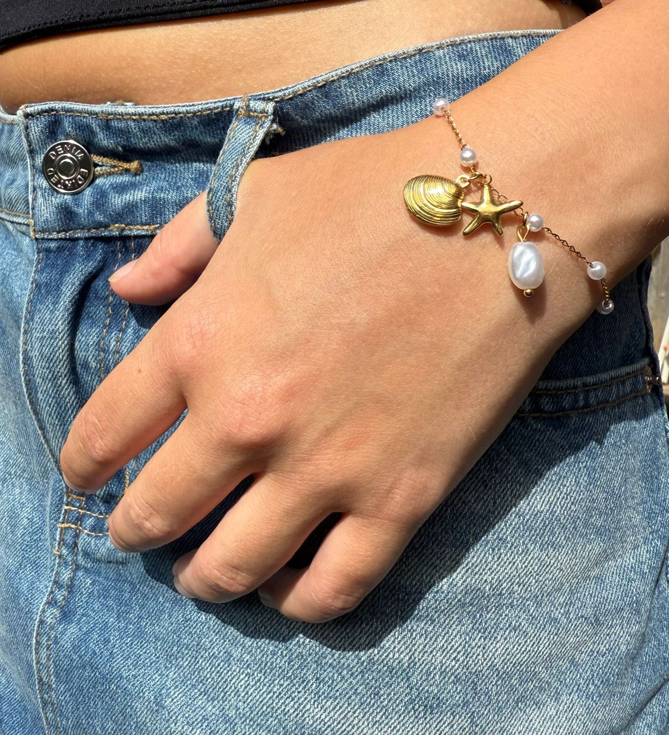 Karter is a 18K AAA gold plated bracelet with a shell, star and pearl charms