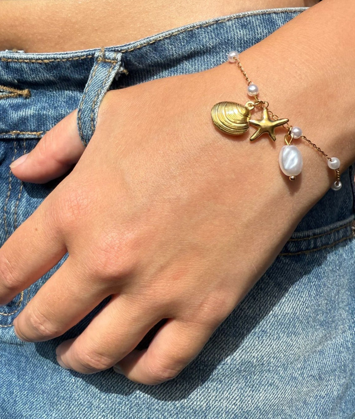 Karter is a 18K AAA gold plated bracelet with a shell, star and pearl charms