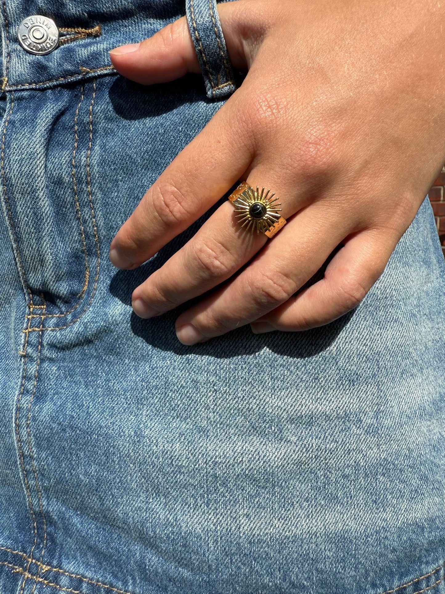 Greer is a 18k AAA gold plated adjustable ring with a sun dial with black stone