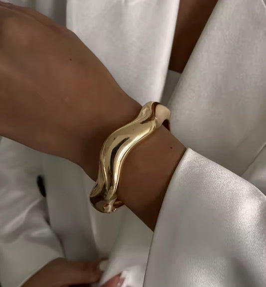 Luella is a wavy gold chunky style bangle