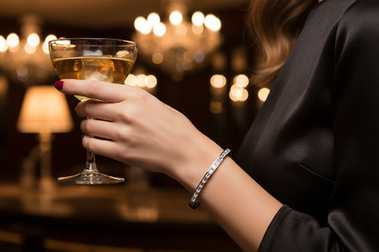 Arm wearing Maddison Bangle holding a cocktail